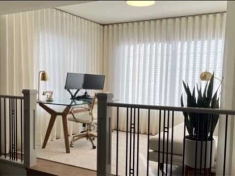 Small office area with soft light coming trough sheer drapes